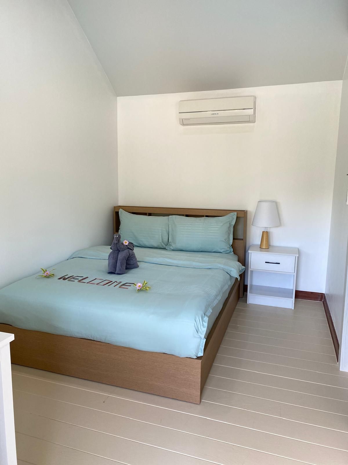 Bright bungalow bedroom with a queen bed and aqua bedding at The White Room