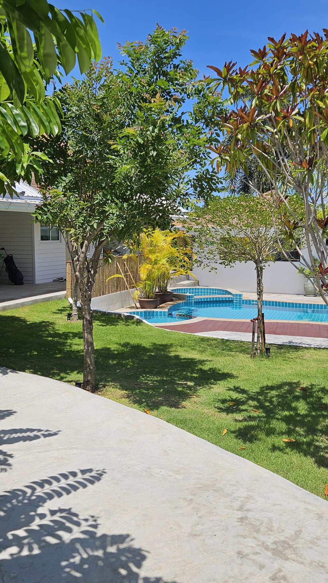 Garden path between the lawn and young trees leading to the swimming pool at The White Room